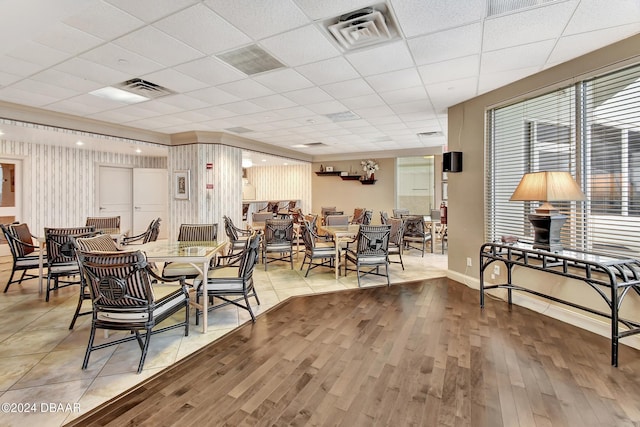 dining area with hardwood / wood-style floors and a paneled ceiling