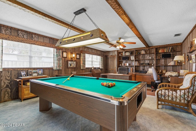 rec room with wood walls, beamed ceiling, a textured ceiling, light colored carpet, and billiards