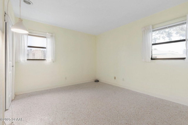 10 Juniper Dr, Ormond Beach, FL 32176 - empty room with speckle patterned floor, healthy amount of natural light, and baseboards