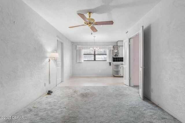 10 Juniper Dr, Ormond Beach, FL 32176 - unfurnished living room with a textured wall, a chandelier, a ceiling fan, and carpet floors
