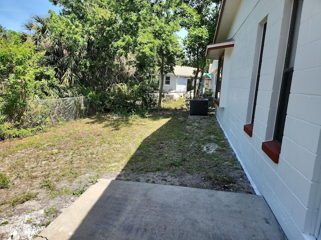 view of yard featuring central air condition unit and a patio