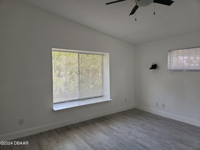 spare room with light hardwood / wood-style floors, ceiling fan, plenty of natural light, and lofted ceiling