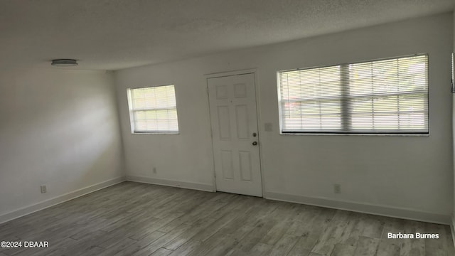 entryway with light hardwood / wood-style floors and a textured ceiling