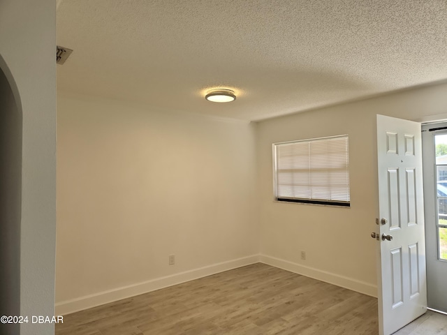 foyer entrance featuring a textured ceiling and light hardwood / wood-style flooring