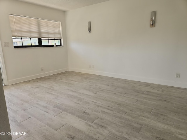 empty room featuring light hardwood / wood-style flooring and a textured ceiling