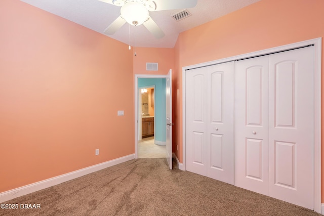 unfurnished bedroom with ceiling fan, light colored carpet, and a closet