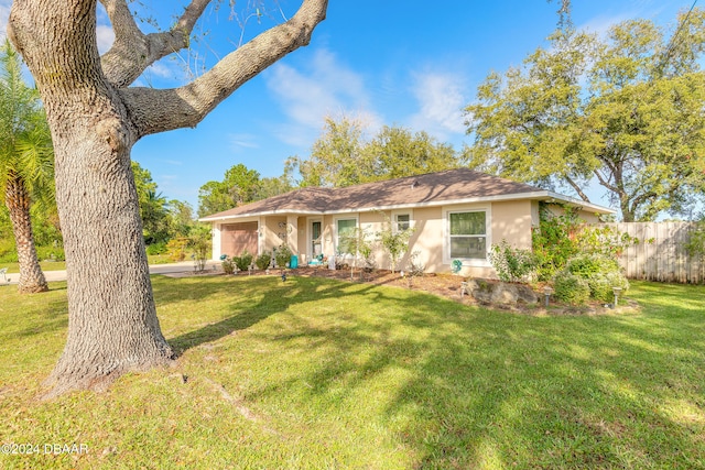 ranch-style house featuring a front lawn and a garage