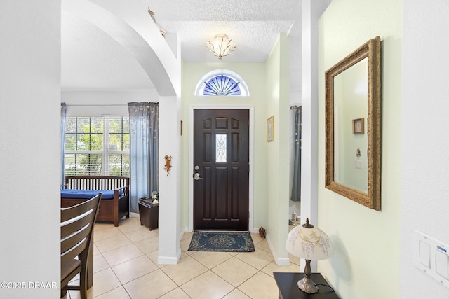 foyer entrance featuring light tile patterned floors and a textured ceiling