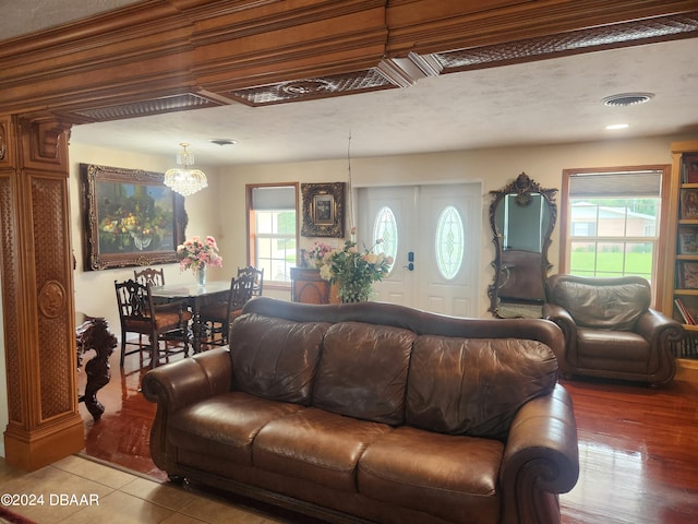 living room with light hardwood / wood-style floors, plenty of natural light, a textured ceiling, and a notable chandelier