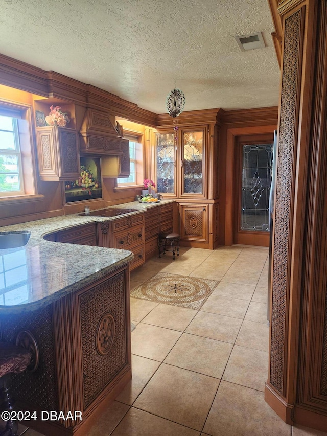 kitchen with black cooktop, a textured ceiling, and light tile patterned floors