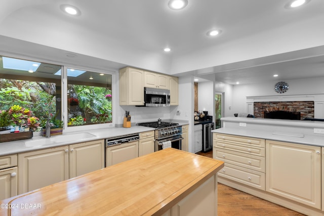 120 Beach St, Ponce Inlet, FL 32127 - kitchen featuring stainless steel appliances, light wood-style flooring, wood counters, a fireplace, and recessed lighting
