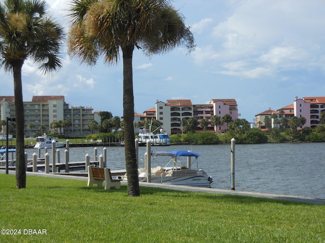 view of dock with a water view and a yard