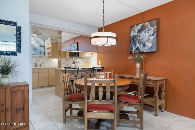 dining space with a textured wall and light tile patterned floors