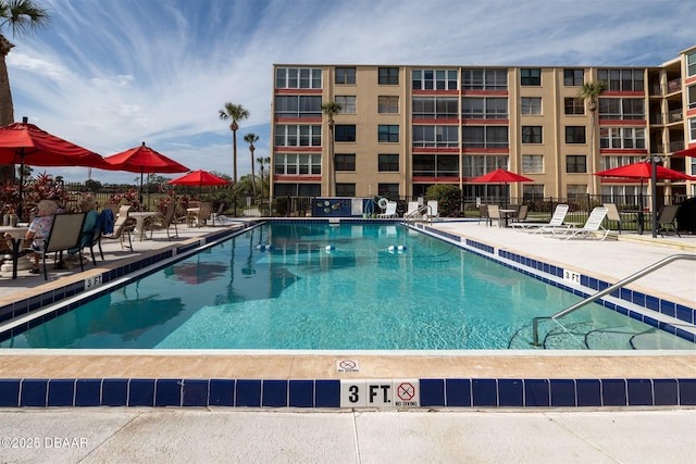 pool with a patio area and fence