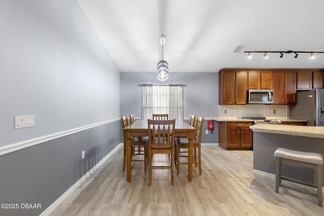 133 Brasswood Ct, Daytona Beach, FL 32117 - dining space featuring light wood-style flooring, baseboards, visible vents, rail lighting, and vaulted ceiling