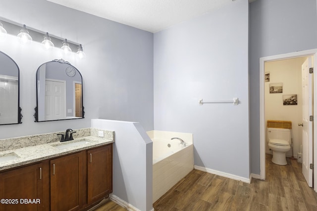 133 Brasswood Ct, Daytona Beach, FL 32117 - bathroom featuring a sink, toilet, wood finished floors, double vanity, and a bath