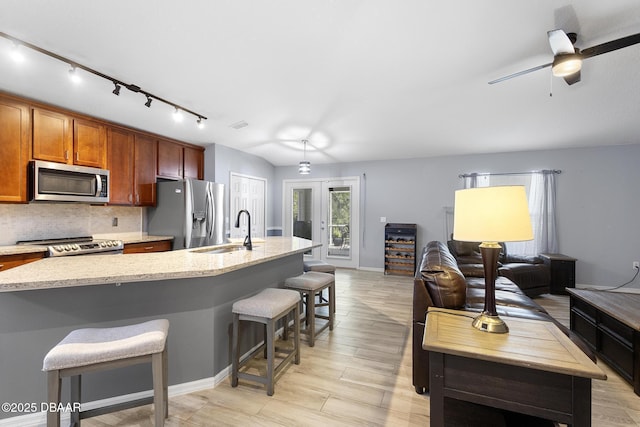 133 Brasswood Ct, Daytona Beach, FL 32117 - kitchen featuring a kitchen bar, a sink, stainless steel appliances, track lighting, and backsplash