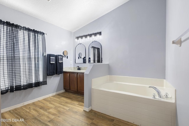 133 Brasswood Ct, Daytona Beach, FL 32117 - full bath featuring wood finished floors, a bath, a textured ceiling, vaulted ceiling, and vanity