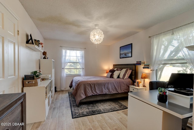 bedroom with a textured ceiling and a chandelier