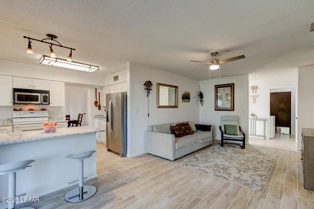 living room featuring a textured ceiling and ceiling fan