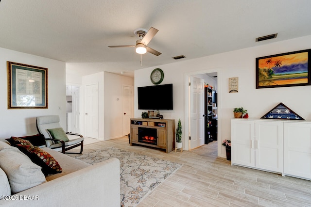 living room featuring ceiling fan and light hardwood / wood-style flooring