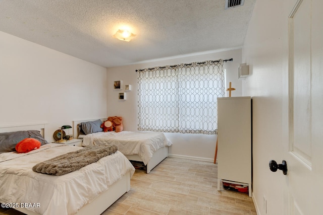 bedroom featuring a textured ceiling and light wood-type flooring