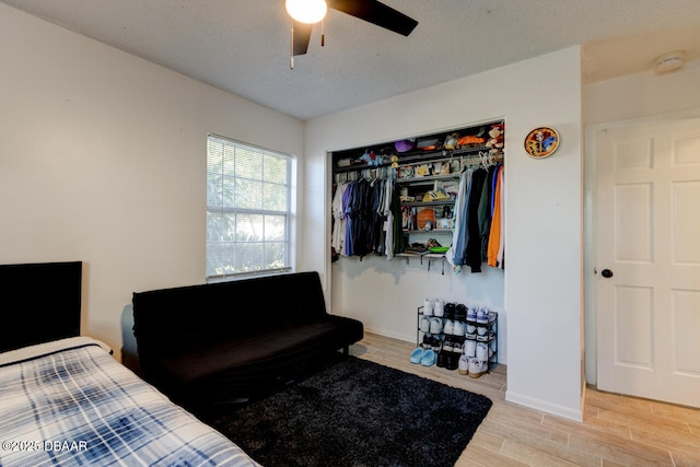 bedroom with ceiling fan, a closet, and a textured ceiling