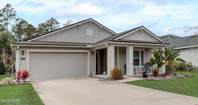 ranch-style house with covered porch, an attached garage, a front lawn, and concrete driveway