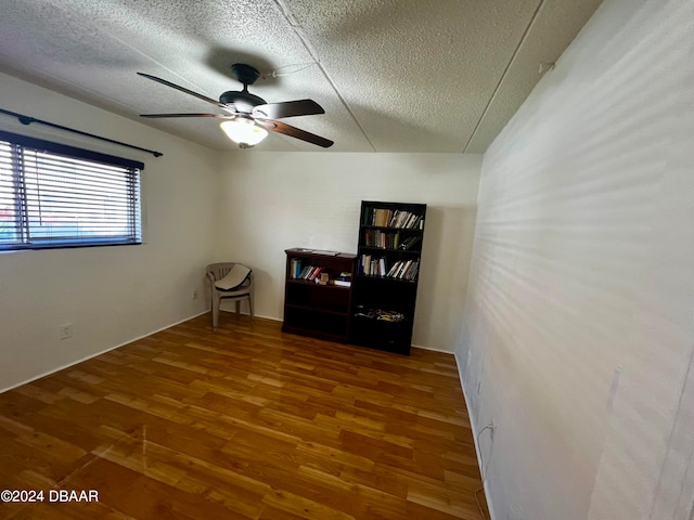 unfurnished room featuring hardwood / wood-style floors, ceiling fan, and a textured ceiling