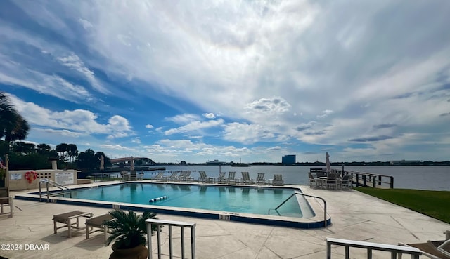 view of swimming pool featuring a patio area and a water view