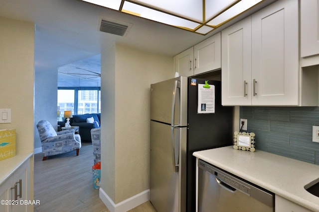 2625 S Atlantic Ave Unit 10Nw, Daytona Beach Shores, FL 32118 - kitchen featuring appliances with stainless steel finishes, light wood finished floors, white cabinets, light countertops, and decorative backsplash