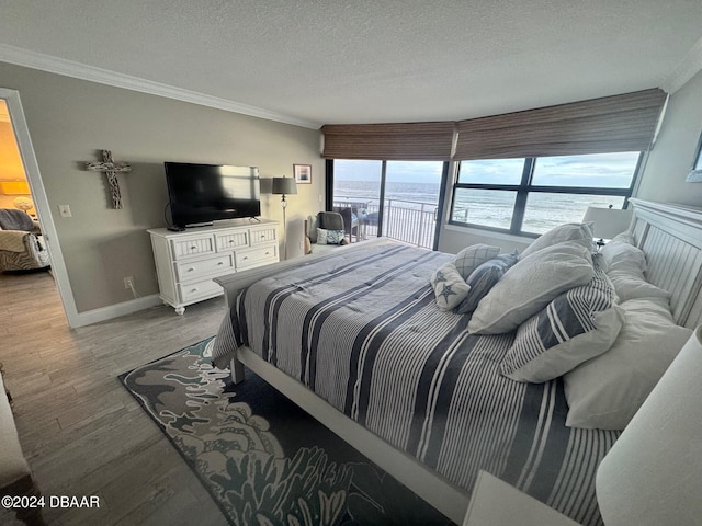 bedroom with hardwood / wood-style flooring, crown molding, and a textured ceiling