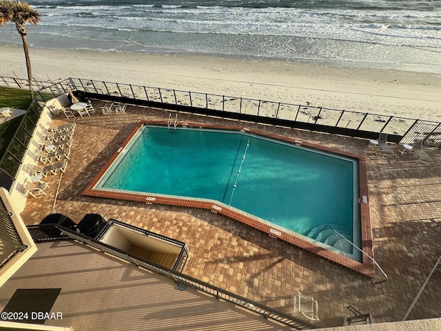 view of pool with a view of the beach and a water view