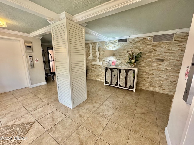 hallway with a textured ceiling, tile patterned floors, and crown molding