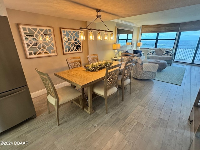 dining area with hardwood / wood-style floors and a water view