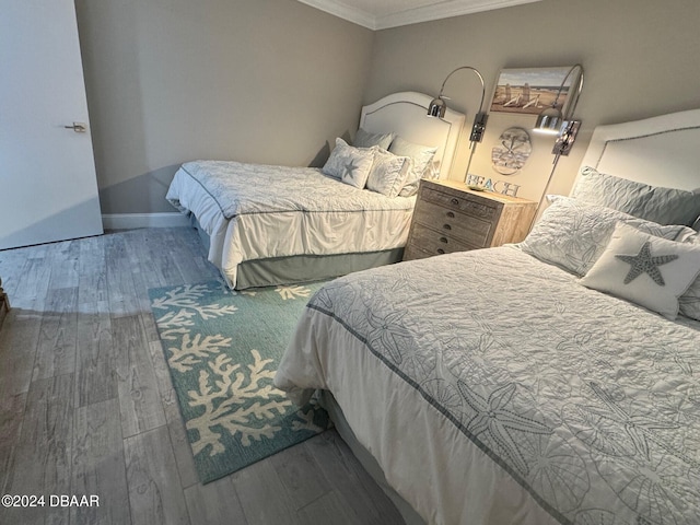 bedroom featuring hardwood / wood-style flooring and crown molding