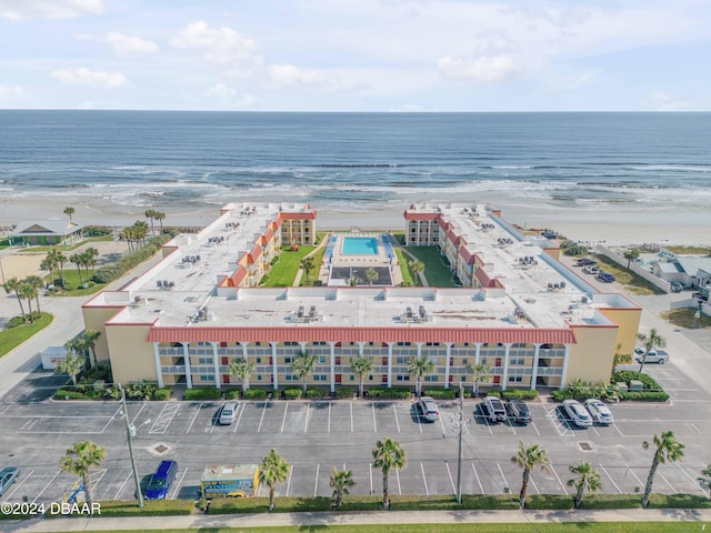 birds eye view of property with a water view and a beach view