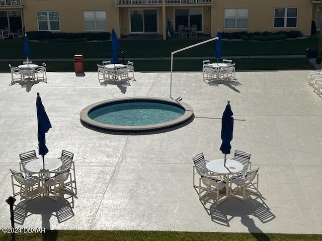 view of pool featuring an outdoor hot tub, a patio area, and a lawn