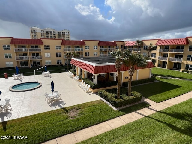 exterior space with a yard, a community hot tub, and a patio