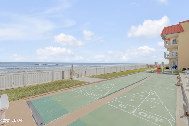 view of home's community with a view of the beach, a water view, and a lawn