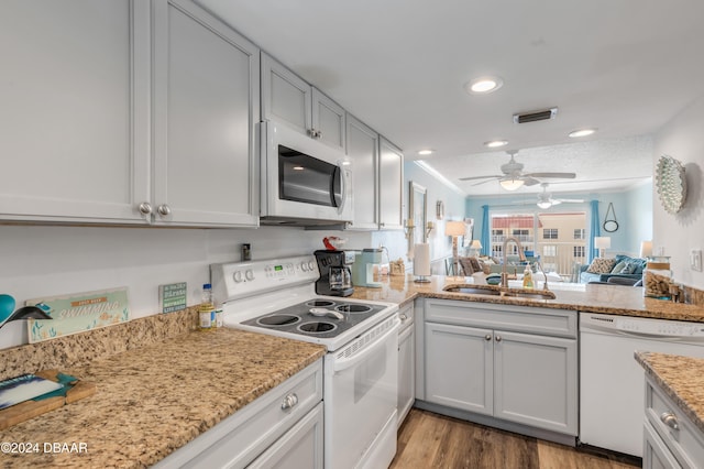 kitchen with white appliances, ceiling fan, sink, light hardwood / wood-style flooring, and white cabinetry