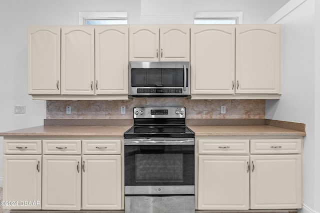 kitchen with decorative backsplash, stainless steel appliances, and plenty of natural light