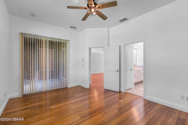 unfurnished bedroom featuring ensuite bathroom, wood-type flooring, and ceiling fan