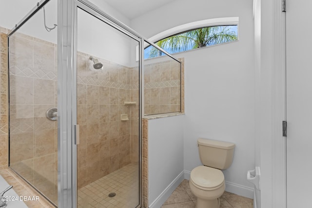 bathroom with tile patterned flooring, toilet, and an enclosed shower