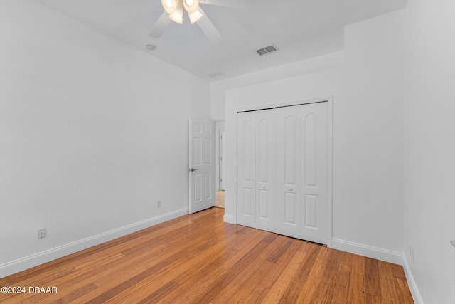 unfurnished bedroom featuring a closet, light wood-type flooring, and ceiling fan