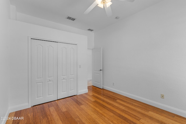 unfurnished bedroom featuring light hardwood / wood-style floors, ceiling fan, and a closet