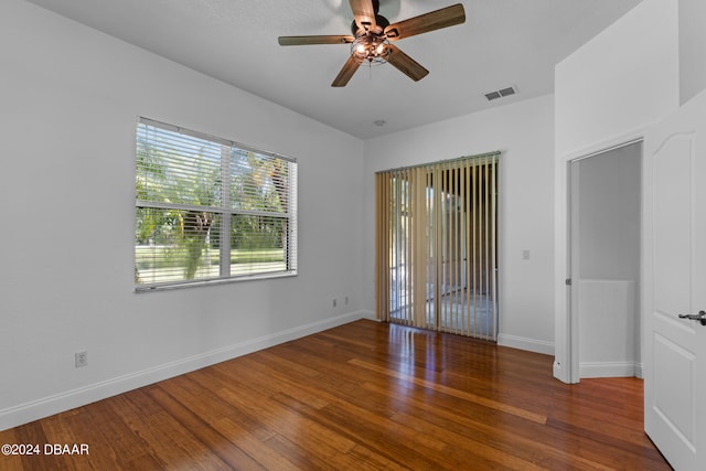 unfurnished room with dark hardwood / wood-style flooring and ceiling fan