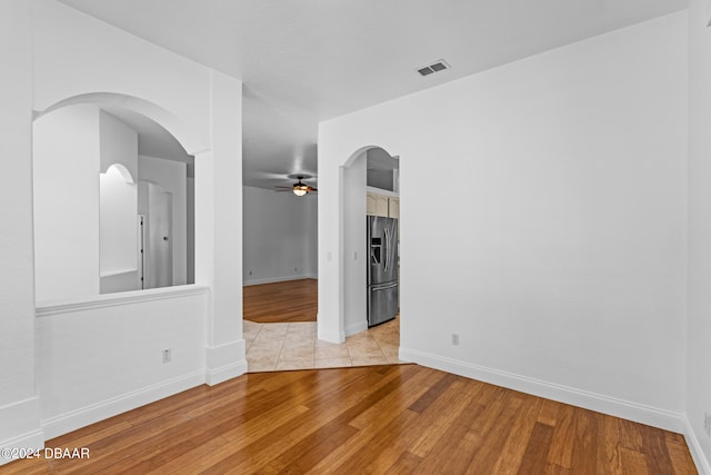 spare room with ceiling fan and light wood-type flooring