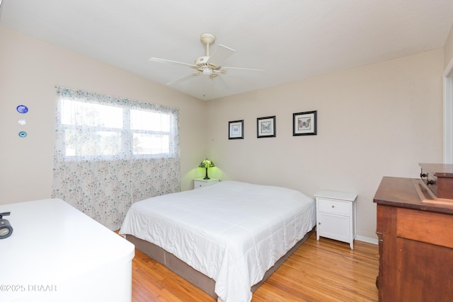 bedroom with ceiling fan, lofted ceiling, and light hardwood / wood-style floors