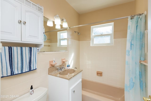 full bathroom featuring shower / tub combo with curtain, vanity, toilet, and tile walls